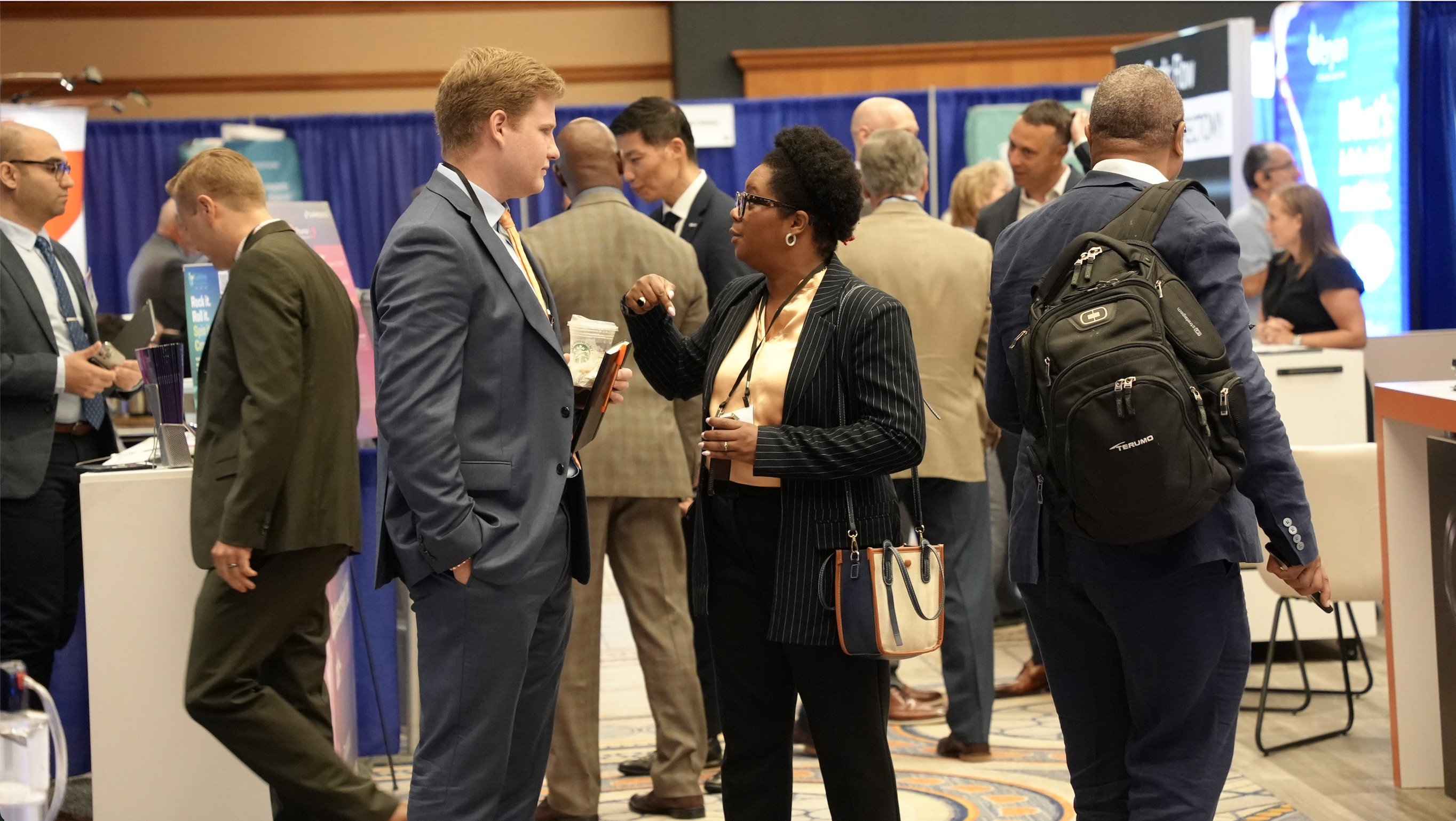 A group of people talking in the Exhibit Hall of a conference