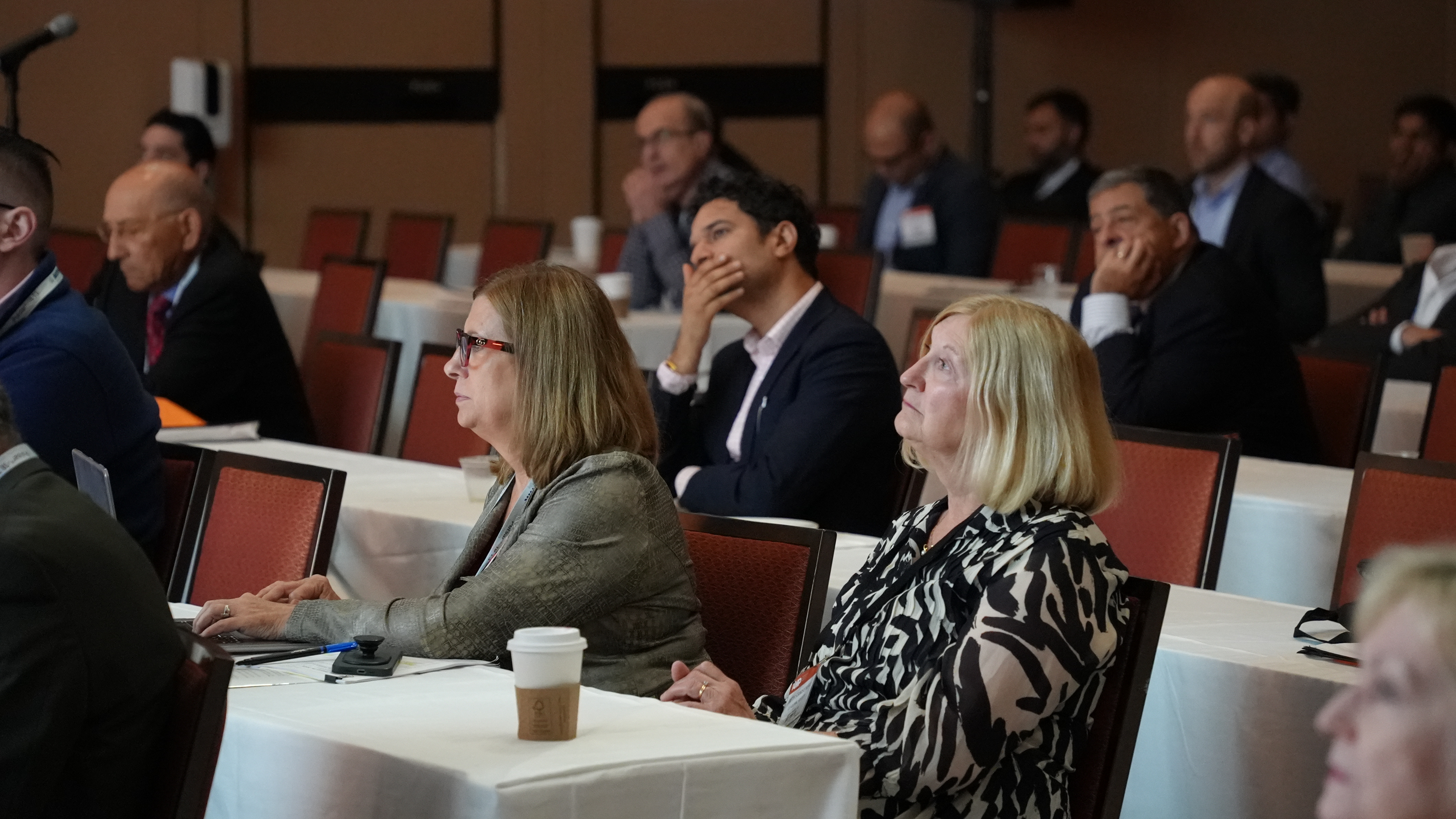Group of conference attendees raptly watching a presentation on vascular procedures