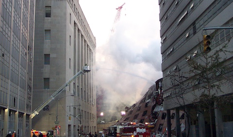 Firefighter in a bucket truck spraying water on the World Trade Center rubble