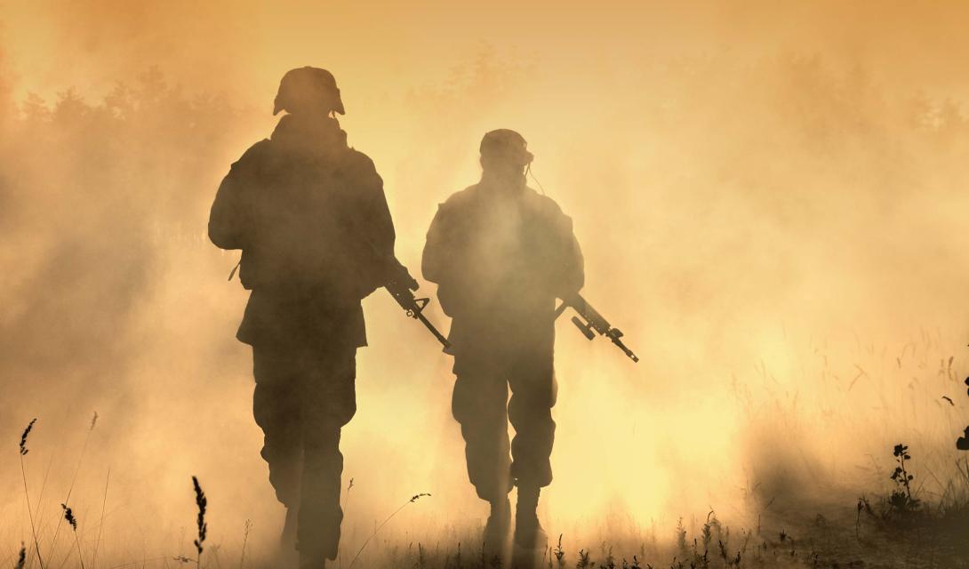 silhouette of two soldiers holding guns 