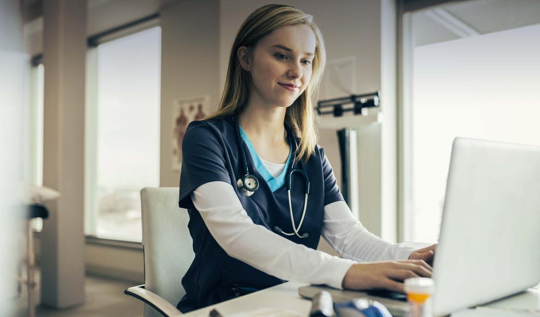 Stock photo of a nurse typing on a keyboard