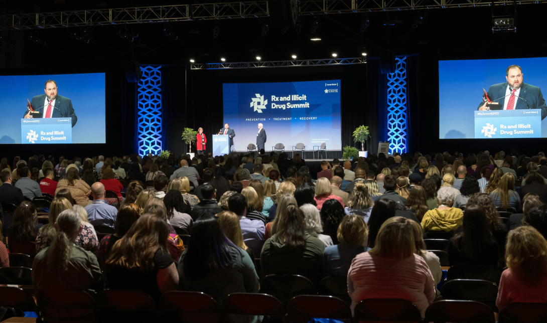 large room full of people listening to a presentation